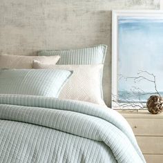 a bed with blue and white comforters in a bedroom