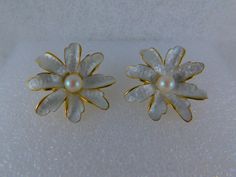 Stunning, shimmering silky smooth pearlized daisy bloom on a brilliant gold base w/textured backs. Earrings measure about 1 inch in diameter. Solid, well-made quality clip-on earrings....Pat. 196452 on the clip of each earring. Nearly pristine condition. Formal White Clip-on Flower Earrings, White Clip-on Flower Earrings For Gifts, Pearl Flower Earrings For Anniversary, White Pearl Flower Earrings For Formal Occasion, White Clip-on Flower Earrings, White Flower-shaped Pearl Earrings For Formal Events, White Flower Clip-on Earrings, White Floral Pearl Earrings For Formal Events, White Floral Pearl Earrings For Formal Occasions