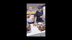 two men are preparing food in the kitchen