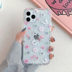 a woman holding an iphone case with flowers on it