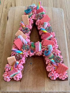 a letter made out of ice cream and sprinkles on a cutting board