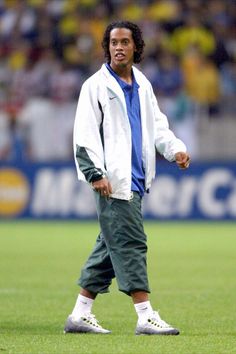 a man standing on top of a soccer field next to a green grass covered field