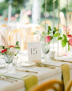 the table is set with flowers and place cards