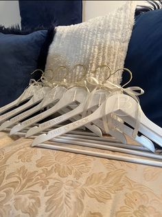 a pile of clothes hangers sitting on top of a bed next to blue pillows