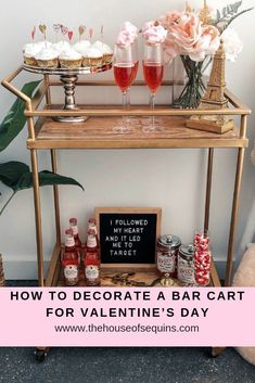 a bar cart for valentine's day with pink roses and cupcakes on it