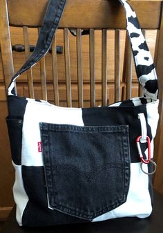 a black and white purse sitting on top of a wooden chair