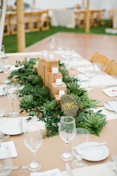 the table is set with white plates and place settings