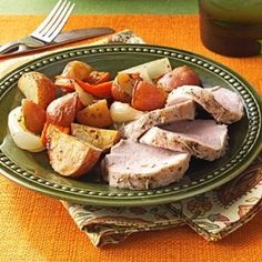 a green plate topped with meat and veggies on top of a yellow table cloth