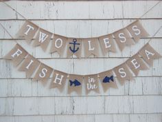 two less fish in the sea banner hanging on a house's exterior wall with an anchor