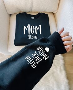 the mom and baby t - shirts are being held up by someone's hand