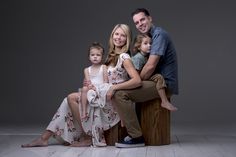 a family posing for a photo in front of a gray background