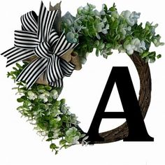 the letter a is decorated with green leaves and flowers on it's front door