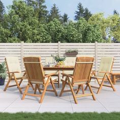 a wooden table and chairs sitting on top of a white tile floor next to a fence