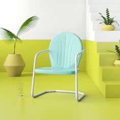 a green chair sitting on top of a yellow floor next to some potted plants