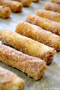 some sugar coated doughnuts are on a baking sheet