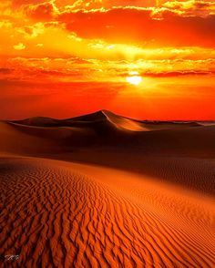 the sun is setting over sand dunes in the desert