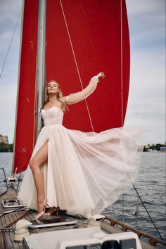 a woman in a white dress posing on a sailboat