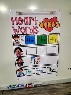 a whiteboard with words and pictures on it in front of a wooden floor that says heart words