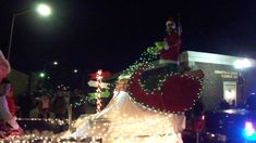 a parade float is decorated with christmas lights and santas on it's back