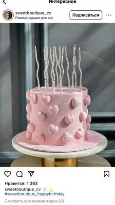 a pink birthday cake with candles on it