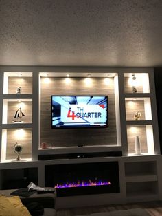 a flat screen tv mounted to the side of a wall next to a fire place