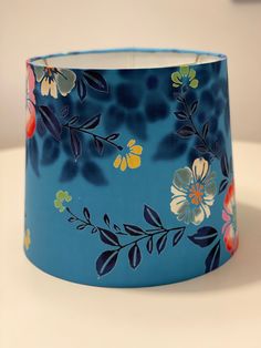 a blue lamp shade with flowers painted on it