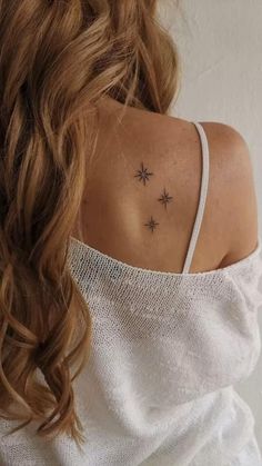 the back of a woman's shoulder with stars on her left and right arm