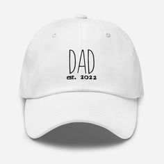 "Got a new Dad in your life that was established this year in 2022? This is the perfect gift for him! Also makes for a great hat to wear during a pregnancy announcement or a gender reveal party!! The black embroidery that says \"Dad est. 2022\" looks perfect against the different color choices of the hat. Make sure to also check out the matching Mama version for extra cute pictures! <3 ❤ 100% chino cotton twill ❤  Green Camo color is 35% chino cotton twill, 65% polyester ❤  Adjustable strap with antique buckle ❤  Head circumference: 20 ½″-21 ⅝″ (50.8 cm-53.3 cm)" Gift For New Dad, Black Embroidery, Gifts For New Dads, Camo Colors, Reveal Party, Perfect Gift For Him, New Dads, Reveal Parties, Gender Reveal Party