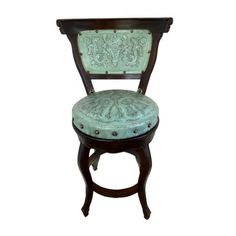 an antique chair with green upholstered fabric