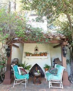 a patio with two chairs and a fire place