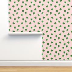 a green wallpaper with four leaf clovers on it and a white door frame