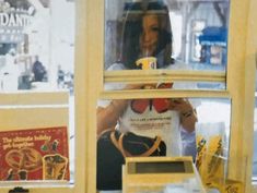 a woman looking through the window of a store