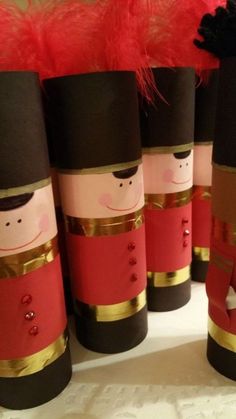 these nutcrackers are made out of paper and have red feathers on them