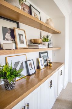 some shelves with pictures and plants on them