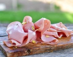 some ham is sitting on top of a piece of wood