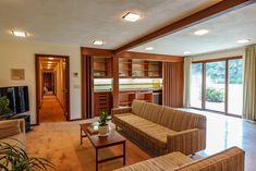 a living room filled with furniture and lots of windows