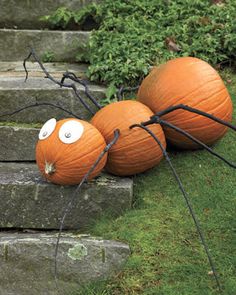 three pumpkins with googly eyes sitting on some steps