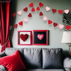 a living room filled with furniture and framed hearts on the wall next to a window