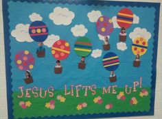 a bulletin board with hot air balloons and the words jesus lifts me up