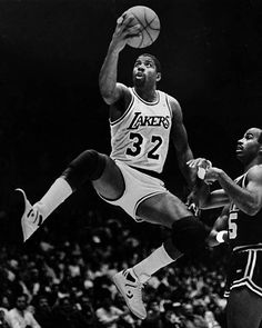 an old black and white photo of a basketball player jumping up to dunk the ball