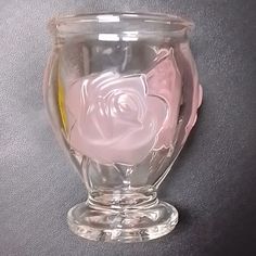 a clear glass vase with a pink rose on the inside and yellow in the outside