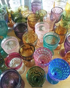 many different colored glass bowls on a table