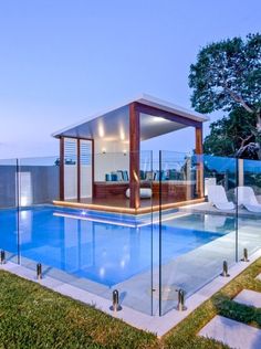 an outdoor swimming pool with glass railings and steps leading up to the deck area