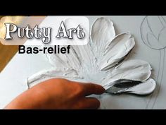 a person is painting a flower with white paint on it and the words, putty art