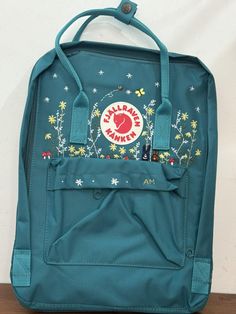 The product you received is an embroidered Kanken backpack The backpack is produced and used in Vietnam market  Actual color may be slightly different due to phone light The package you receive includes backpack and hand-embroidered design as shown. Please read the information carefully to choose the color you want for Version & Size: Version & Size - Kanken No.1: This is the classic (original) version with 3 sizes + Mini size: 29x20x13cm (A5 paper size) + Medium size: 27x38x13cm (laptop 15 inch size) + Large size: 35x45x15cm (laptop 17 inch size) => For the Large size, there are just few color choices so Please look carefully at the color description photo. - Kanken No.2: This is the version with leather straps + Mini size: 29x20x13cm (A5 paper size) + Medium size: 27x38x13cm (laptop 14 i Casual Backpack With Embroidered Logo For Daily Use, School Backpack With Floral Embroidery, Casual Floral Embroidered Backpack, Casual Floral Embroidery Backpack, Everyday Backpack With Embroidered Logo, Standard Backpack With Embroidered Logo For Daily Use, Daily Use Backpack With Embroidered Logo, Travel Backpack With Embroidered Logo, Travel Bags With Embroidered Logo For Back To School