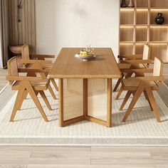 a wooden table with chairs around it on a rug in front of a bookshelf