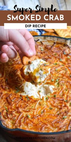 someone dipping some food into a casserole dish with cheese and herbs on top