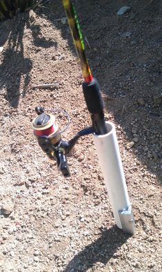 a fishing rod is attached to the handlebars of a spinning reel on gravel