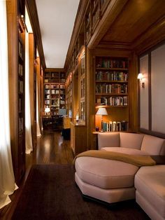 a living room filled with lots of books and furniture