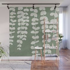 a green and white wallpaper with leaves on it in a living room area next to a window